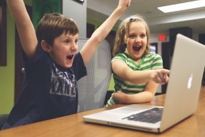 2 children celebrating at computer